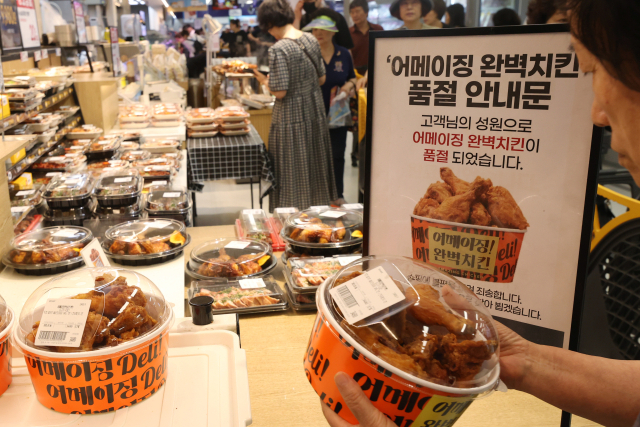6일 서울의 한 이마트에서 시민이 치킨 구매 번호표와 치킨을 교환하고 있다. 이마트는 이날까지 100% 국내산 냉장육을 튀긴 