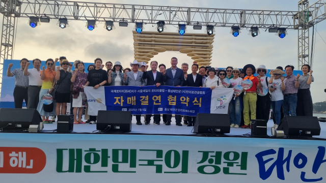 지난 5일 충암 태안군 만리포해수욕장 개장 70주년 축하 무대에서 박준희 국제로타리3640지구 서울패밀리로타리 클럽 회장(앞줄 왼쪽 여덟 번째)이 전완수 만리포관광협회장(앞줄 왼쪽 아홉 번째)이 자매결연을 체결하고 기념촬영을 하고 있다. [사진=아이넷방송그룹]