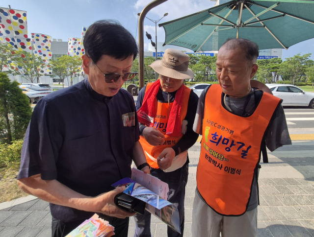 이범식 박사(사진 오른쪽)가 7일 광주광역시청 앞에서 시민에게 APEC정상회의 홍보를 하고 있다. 이범식 서포터즈 김선완 단장 제공