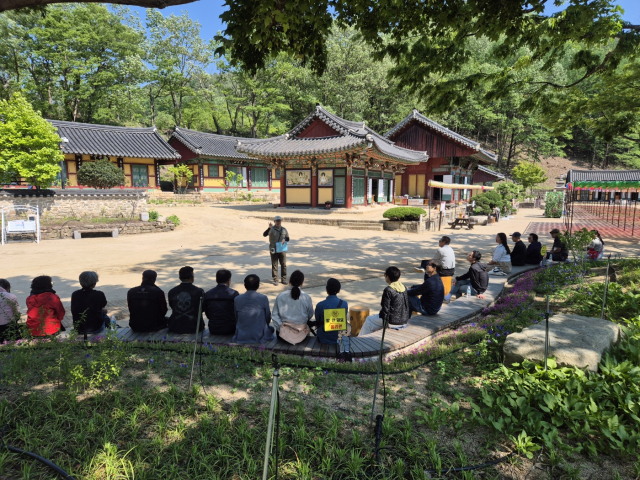 국립공원 생태관광에 참여한 관광객들이 해설사를 통해 주왕산에 관한 설명을 듣는 모습. 주왕산국립공원사무소 제공