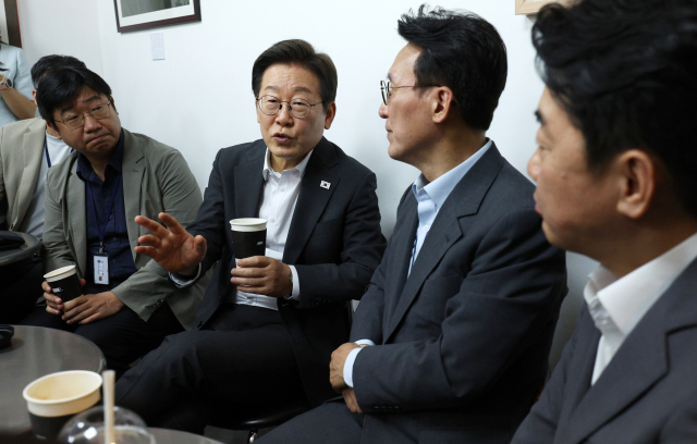 이재명 대통령과 김민석 국무총리, 강훈식 대통령비서실장이 8일 용산 대통령실 직원식당에서 식사 후 매점에서 만난 기자들과 차를 마시며 대화하고 있다. 연합뉴스