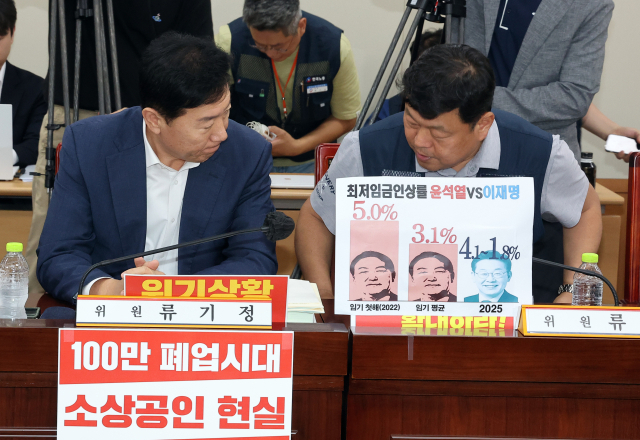 최저임금위원회 사용자위원인 류기정 한국경영자총협회 전무(왼쪽)와 근로자위원 류기섭 한국노총 사무총장이 10일 정부세종청사에서 열린 최저임금위원회 제12차 전원회의에 입장하며 인사를 나누고 있다. 연합뉴스