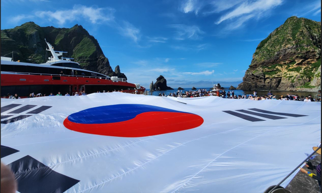 광복 80주년을 맞아 지난달 28일 시민 80명이 독도 동도 선착장에서 가로 30m, 세로 20m 크기의 초대형 태극기를 펼치고 있다. 연합뉴스