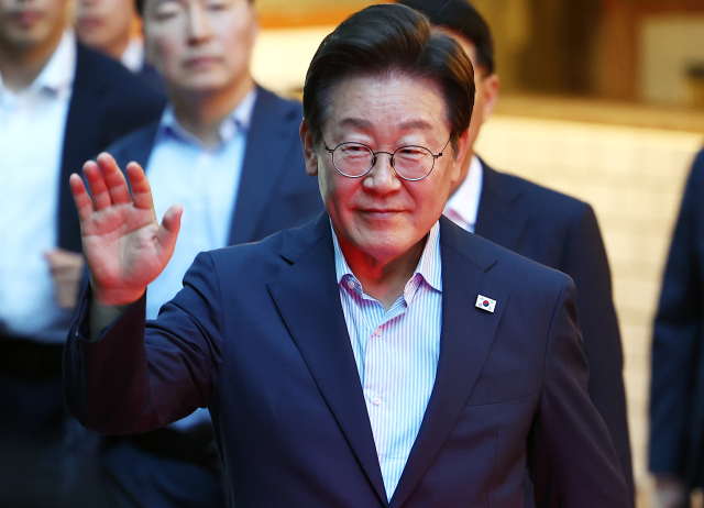 이재명 대통령이 11일 저녁 서울 광화문 인근 한식당에서 나오며 시민들에게 손을 흔들고 있다. 이 대통령은 식당을 찾기 전 SNS에 식사 계획을 알리며 