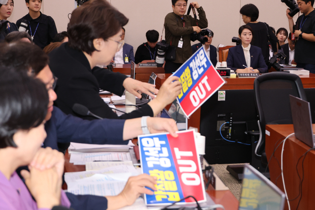 14일 국회 여성가족위원회에서 열린 강선우 여성가족부 장관에 대한 인사청문회에서 국민의힘 의원들이 강 후보자 사퇴를 요구하는 피켓을 여당의 항의가 이어지자 떼어내고 있다. 연합뉴스