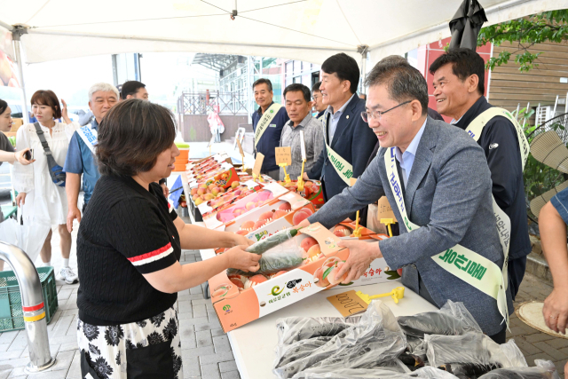 김진열 대구 군위군수와 한국후계농업경영인 군위군 연합회 회원들이 여름 휴가철을 맞아 중앙고속도로 군위휴게소(대구 방향)에서 군위 으뜸 농산물을 판매하고 있다. 군위군 제공