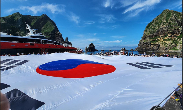 광복 80주년을 맞아 지난 28일 시민 80명이 독도 동도 선착장에서 가로 30m, 세로 20m 크기의 초대형 태극기를 펼치고 있다. [서경덕 교수 제공]