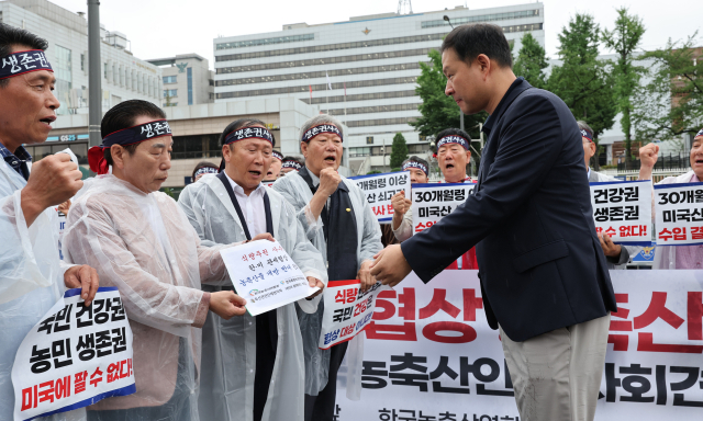 18일 서울 용산구 대통령실 앞에서 한국농축산연합회 등 농축산 단체 회원들이 한미 상호관세 협상 농축산물 개방 반대 건의문을 대통령실 관계자에게 전달하고 있다. 연합뉴스