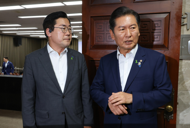 더불어민주당 당 대표 후보자인 정청래(오른쪽)·박찬대 의원이 3일 서울 여의도 국회에서 열린 비공개 의원총회장 앞에서 대화하고 있다. 연합뉴스
