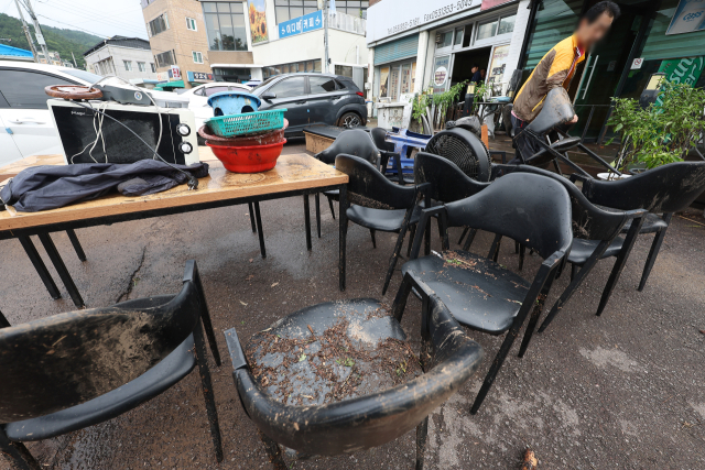 18일 전날 내린 폭우로 침수 피해를 본 대구 북구 노곡동 한 식당에서 주민이 복구 작업을 하고 있다. 연합뉴스