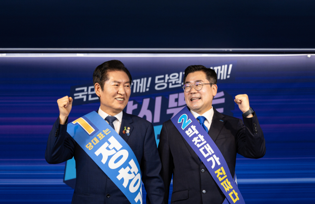 더불어민주당 대표 선거에 출마한 정청래(왼쪽), 박찬대 후보가 19일 서울 여의도 당사에서 열린 합동연설회에서 함께 주먹을 쥐며 인사하고 있다. 연합뉴스