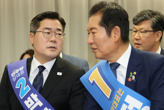 더불어민주당 정청래·박찬대(왼쪽) 당대표 후보가 20일 서울 여의도 당사에서 열린 8·2 전당대회 순회 경선 영남권 합동연설회에서 대화하고 있다. 연합뉴스