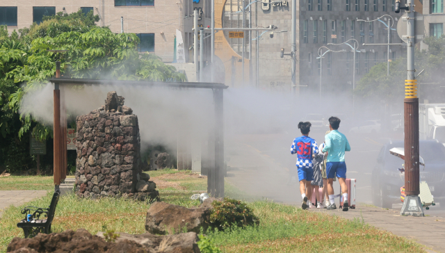 제주도 해안에 폭염주의보가 내려진 18일 오전 서귀포시 서귀동 자구리공원에 설치된 쿨링포그 폭염쉼터에 사람들이 오가고 있다. 연합뉴스