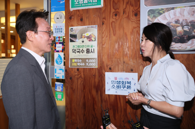 김민석 국무총리가 민생회복 소비쿠폰 신청 시작일인 21일 서울 노원구 한 식당을 찾아 식당 주인과 대화하고 있다. 연합뉴스