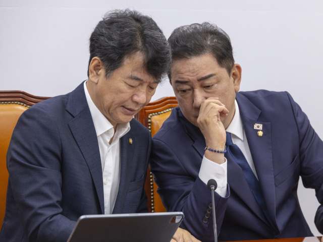 더불어민주당 김병기 당 대표 직무대행 겸 원내대표와 문진석 원내수석부대표가 22일 국회에서 열린 원내대책회의 도중 대화하고 있다. 연합뉴스