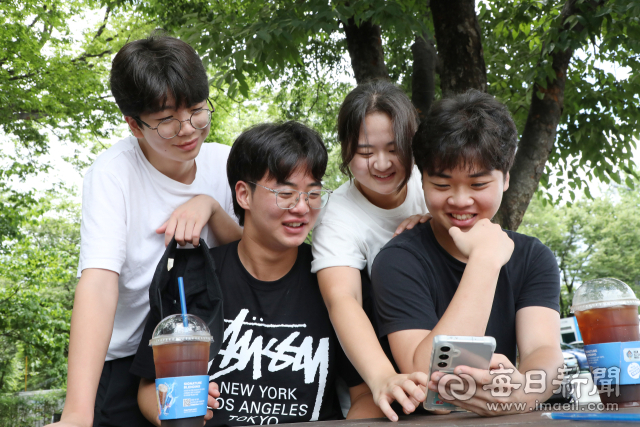 (왼쪽부터 시계방향)넷째 지원, 첫째 시은, 셋째 서원, 둘째 주원 등 4남매가 스마트폰에 저장된 가족사진을 함께 보며 환하게 웃고 있다. 정운철 기자 woon@imaeil.com