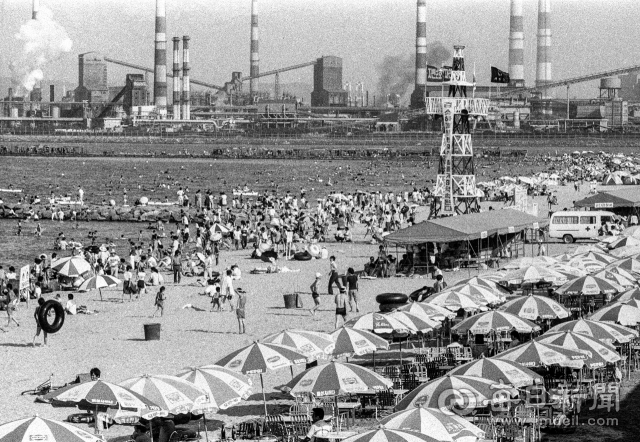 1990년대 초 포항 송도해수욕장 코앞에 제철소(포스코) 굴뚝에서 연기를 내뿜는 가운데 피서객들이 모래 유실 방지용 돌제(방파제) 주변에서 해수욕을 즐기고 있다. 사진=매일아카이빙센터