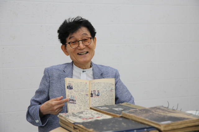 임무상 화백이 중학교 2학년 때인 1957년 쓴 일기를 펼쳐 보이며 활짝 웃고 있다. 김도훈 기자