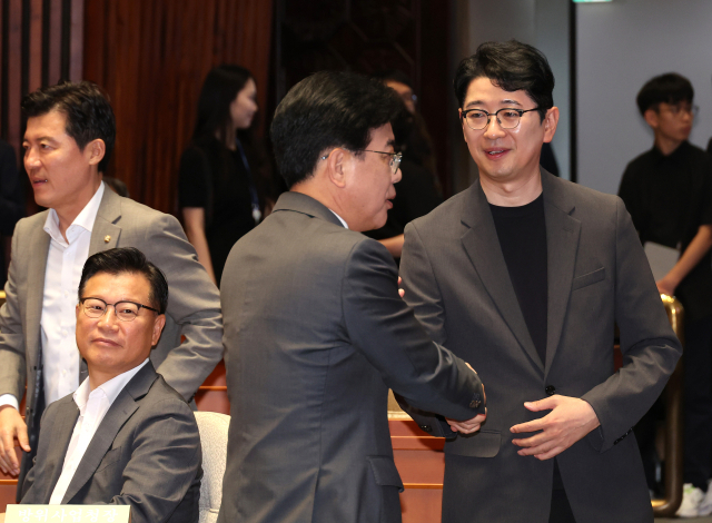 국민의힘 송언석 비상대책위원장 겸 원내대표(왼쪽)가 23일 서울 여의도 국회에서 열린 의원총회에서 주진우 의원과 악수하고 있다. 연합뉴스