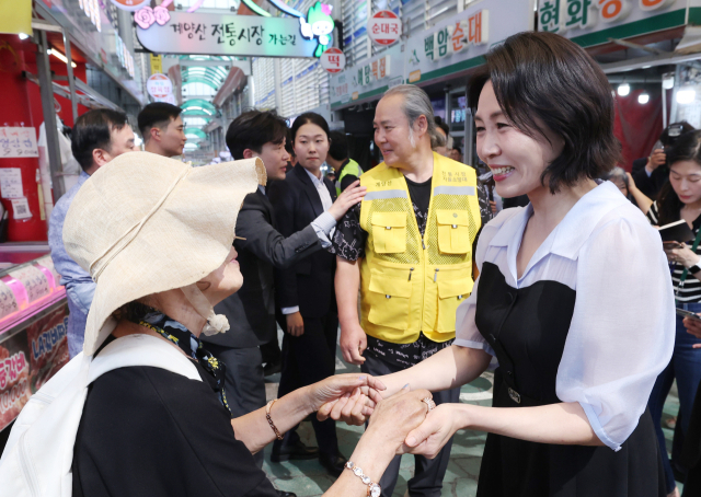 김혜경 여사가 25일 인천 계양산전통시장을 방문해 한 시민과 인사하고 있다. 연합뉴스