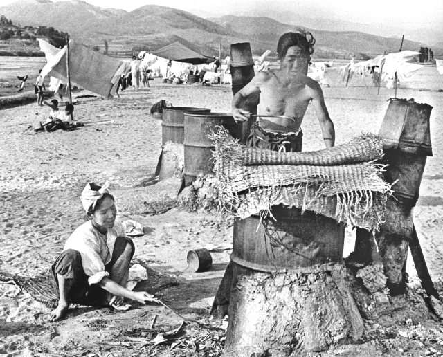 1955년 여름날 팔달교 아래 금호강 백사장에서 아낙네들이 드럼통을 잘라 만든 가마솥에 빨랫감을 삶고 있다. 매일아카이빙센터