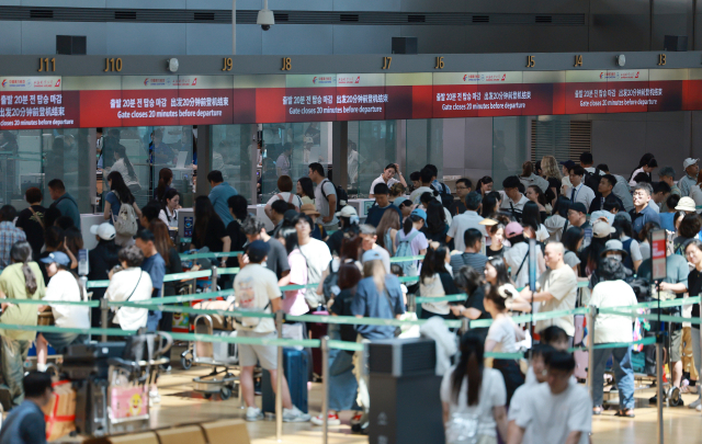 27일 여름 성수기를 맞은 인천국제공항 제1여객터미널 출국장에서 승객들이 탑승 수속을 위해 줄을 서고 있다. 인천국제공항공사에 따르면 올여름 성수기 기간 인천공항 이용객은 387만2천명으로 하루 평균 22만8천명에 달할 전망이다. 연합뉴스