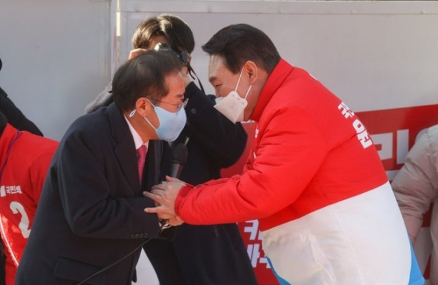 20대 대선 시기였던 지난 2022년 2월 15일 대구 동구 동대구역 광장에서 열린 거점 유세에서 지지 연설을 마친 홍준표 선대본 상임고문(왼쪽)이 윤석열 국민의힘 대선 후보와 악수를 나누고 있다. 연합뉴스