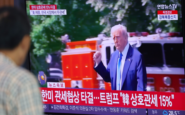 한국과 미국의 관세협상이 타결된 31일 서울역 대합실에서 한 시민이 관련 뉴스를 시청하고 있다. 연합뉴스
