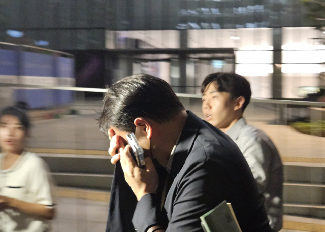 김건희 여사 오빠인 김진우 씨가 28일 김 여사 관련 의혹들을 수사하는 민중기 특별검사팀 사무실이 위치한 서울 종로구 KT광화문빌딩에서 조사를 마친 뒤 얼굴을 가린 채 특검 사무실을 나서고 있다. 김씨는 이른바 