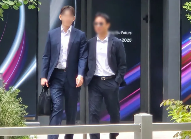 김건희 여사 오빠인 김진우(오른쪽)씨가 31일 김 여사 관련 의혹들을 수사하는 민중기 특별검사팀 사무실이 위치한 서울 종로구 케이티(KT)광화문빌딩웨스트(West)에서 나오고 있다. 연합뉴스