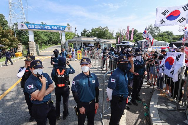 김건희 여사 의혹들을 수사하는 민중기 특별검사팀이 윤석열 전 대통령에 대한 체포영장 집행에 나선 1일 경기 의왕시 서울구치소 앞에서 윤 전 대통령 지지자들이 시위하는 가운데 경찰이 경계근무를 서고 있다. 연합뉴스