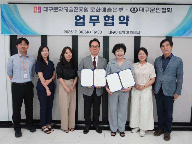 방성택 대구문화예술진흥원 문화예술본부장(왼쪽에서 네번째)과 안윤하 대구문인협회 회장(왼쪽에서 다섯번째)이 업무협약서를 들어보이고 있다. 대구문화예술진흥원 제공