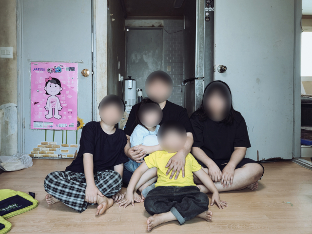 박영현(39·가명, 가운데) 씨는 벽지가 온통 상하고 곰팡이가 핀 오래된 아파트에서 네 아이와 함께 생활하고 있다. 김지효 기자
