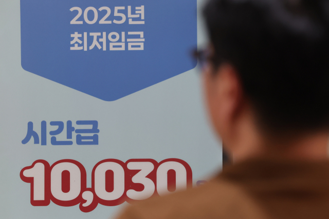내년 최저임금이 올해보다 2.9% 오른 시간당 1만320원으로 결정됐다. 내년 최저임금은 2008년 이후 17년 만에 근로자·사용자·공익위원 합의로 결정됐다. 노사공 합의로 최저임금이 결정된 것은 1988년 최저임금 제도 도입 이후 8번째다. 사진은 13일 서울 마포구 서부고용복지플러스센터에 설치된 2025년 최저임금 안내판. 연합뉴스