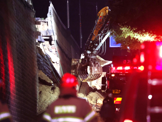 지난달 16일 오후 경기 오산시 가장동 가장교차로 고가도로의 10ｍ 높이 옹벽이 도로로 무너지며 고가도로 아래 도로를 지나가던 차량을 덮치는 사고가 났다. 사진은 사고 현장에서 흙더미를 파내는 굴착기의 모습. 연합뉴스