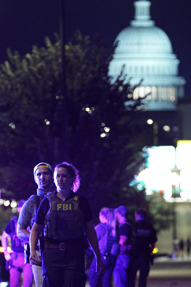 11일(현지시간) 워싱턴 DC 국회의사당 건물을 뒤로하고 FBI 요원들이 순찰을 하고 있다. AFP 연합뉴스
