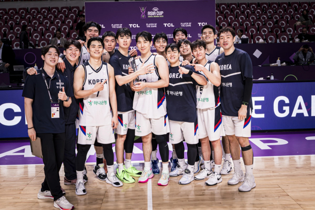 한국 남자 농구 대표팀이 12일 사우디아라비아에서 열린 2025 FIBA 아시아컵 8강 진출전에서 괌을 꺾은 뒤 경기 최우수선수로 선정된 문정현(가운데)과 함께 기념 사진을 찍고 있다. FIBA 홈페이지 제공
