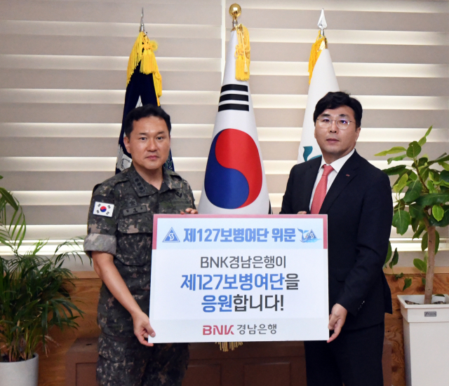 BNK경남은행 황재철 부행장(사진 오른쪽)이 제127보병여단 박정인 사령관에게 위문금을 전달하고 있다. BNK경남은행 제공