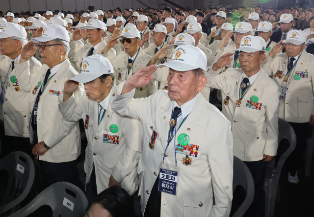 27일 경기도 고양시 킨텍스에서 열린 유엔군 참전의 날 기념식에서 6.25 참전유공자들이 국기에 경례하고 있다. 연합뉴스