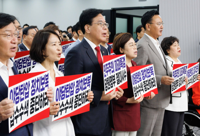 국민의힘 송언석 비상대책위원장 겸 원내대표를 비롯한 당 관계자들이 14일 서울 여의도 중앙당사에서 열린 긴급의원총회에서 전날 김건희 특검의 당사 압수수색과 관련한 규탄 구호를 외치고 있다. 연합뉴스