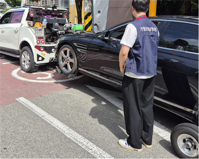 부산 기장군 38세금징수TF팀이 지방세 체납을 원인으로 압류 설정된 차량을 강제견인하고 있다. [사진=기장군]