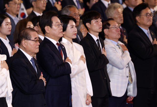이재명 대통령과 김혜경 여사가 15일 서울 세종문화회관에서 열린 80주년 광복절 경축식에서 국기에 경례하고 있다. 연합뉴스
