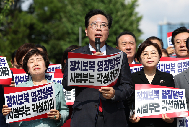 국민의힘 송언석 비상대책위원장 겸 원내대표를 포함한 의원들이 18일 서울 서초구 서울중앙지방법원 앞에서 열린 현장비상의원총회에서 발언하고 있다. 연합뉴스
