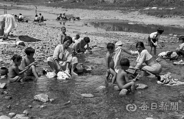 1950년 8월 여름날 대구 신천에 나온 아낙네들이 빨래를 하는 동안 아이들이 냇물에서 더위를 식히고 있다. 미국 종군기자 칼 마이던스 촬영. 매일아카이빙센터