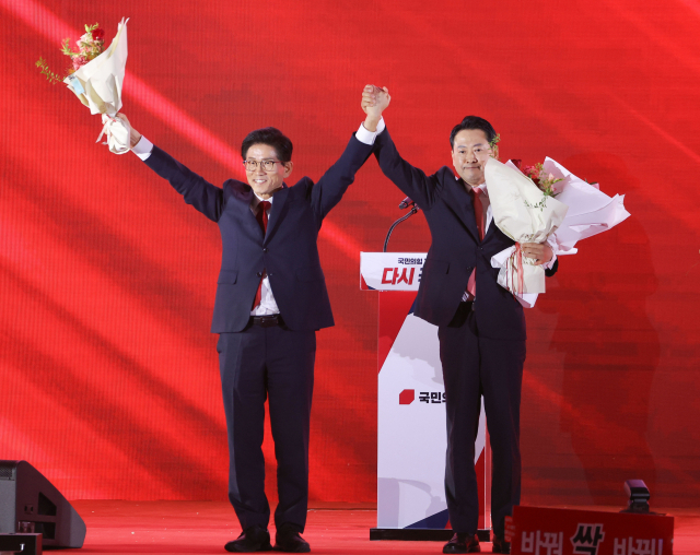 22일 충북 청주시 흥덕구 청주오스코에서 열린 국민의힘 제6차 전당대회에서 결선에 진출한 김문수, 장동혁 당대표 후보가 꽃다발을 받은 뒤 맞잡은 손을 들어 올리고 있다. 이날 국민의힘 당 대표 선거는 4명의 후보가 모두 과반 득표에 실패해 1, 2위를 기록한 김문수, 장동혁 후보가 결선에 진출, 재투표를 실시해 오는 26일 당선인을 발표할 계획이다. 연합뉴스