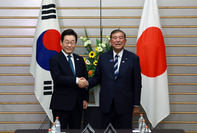 이재명 대통령과 이시바 시게루 일본 총리가 23일 일본 도쿄 총리 관저에서 열린 한일 확대정상회담에 앞서 기념촬영을 하며 악수하고 있다. 연합뉴스