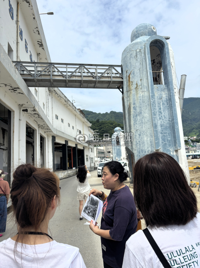 경북 울릉도 저동항 냉동공장 앞에 설치된 팽귄 구조물. 울릉도를 찾은 외국인 광광객에게 팽귄 구조물을 설명하고 있는 김민정씨. 김민정씨 제공