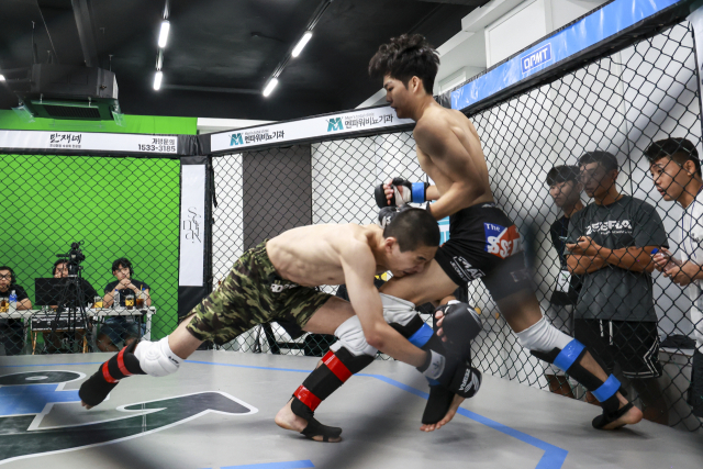 23일 KMMA 플라이급 1차 방어전에 나선 챔피언 문순수(왼쪽)가 도전자 김민기에게 태클을 시도하고 있다. KMMA 제공