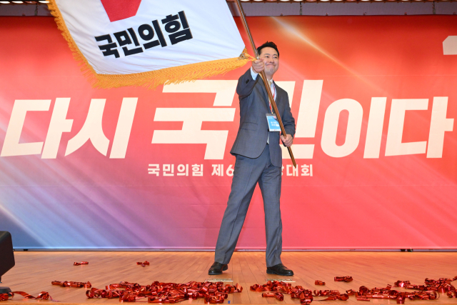 국민의힘 장동혁 신임 당 대표가 26일 서울 여의도 국회도서관에서 열린 제6차 전당대회 결선에서 당 대표로 선출된 뒤 당기를 흔들고 있다. 연합뉴스