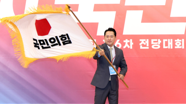 국민의힘 장동혁 신임 당 대표가 26일 서울 여의도 국회도서관에서 열린 제6차 전당대회 결선에서 당 대표로 선출된 뒤 당기를 흔들고 있다. 연합뉴스